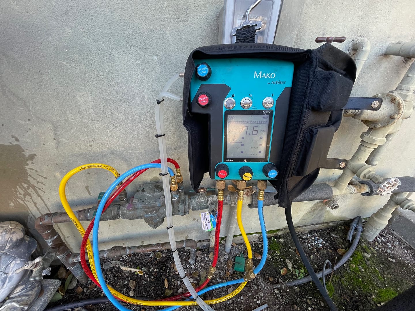 Image: A technician performing backflow testing in Cupertino, with testing equipment and valves visible against a backdrop of Cupertino's urban landscape.