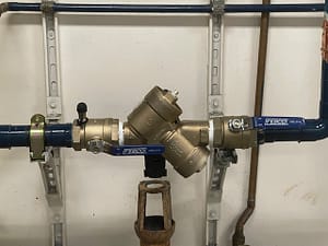Image: A technician repairing a backflow prevention system, ensuring water safety and compliance.